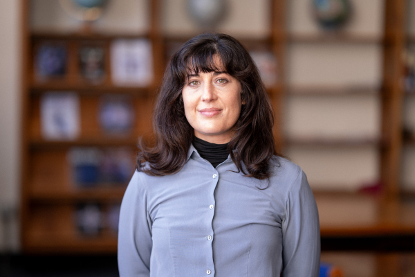 Photo of Amanda Nutter in a library smiling with a blue button up top