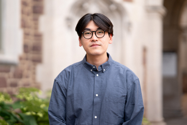 Photo of Tae Sung Oh wearing glasses in a blue button-up shirt