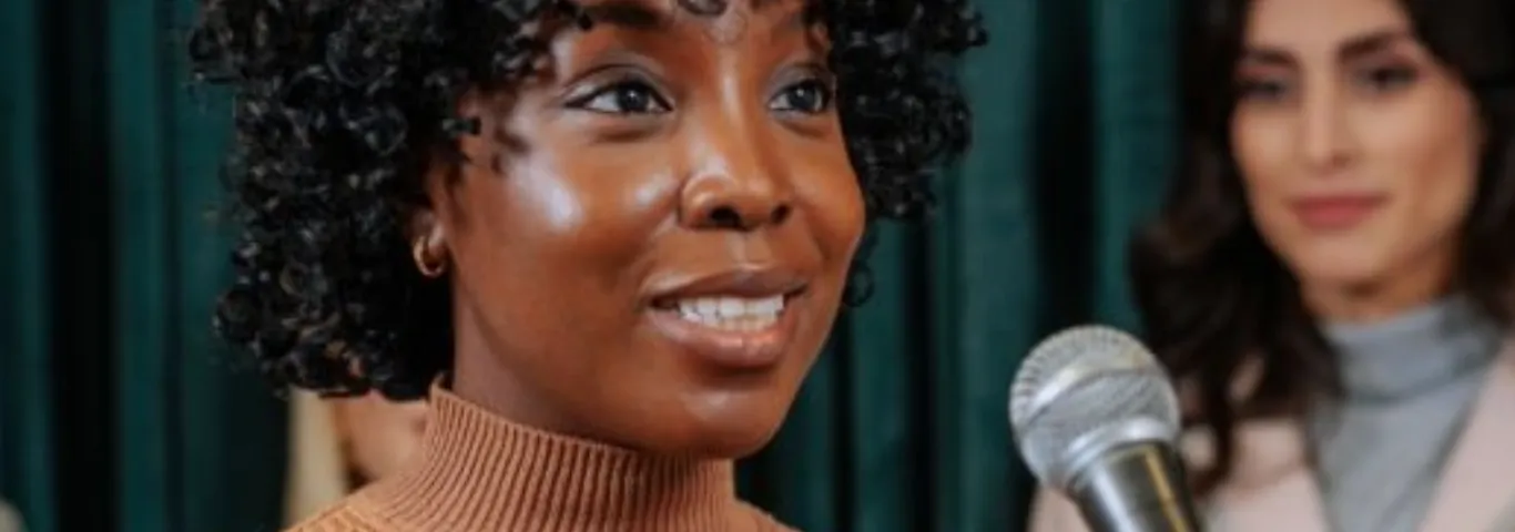 Woman speaks into a microphone.