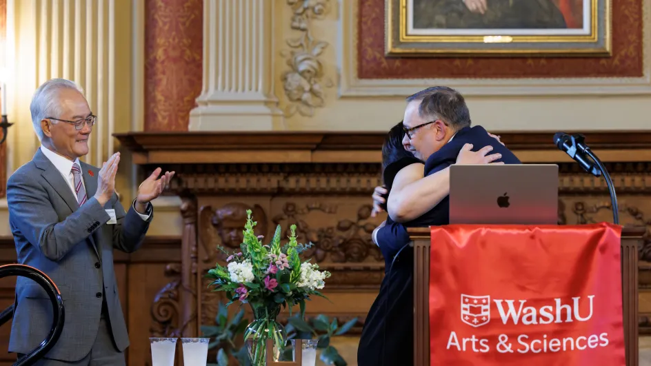 Photo of Betsy Sinclair hugging Andrew Martin as Dean Hu claps