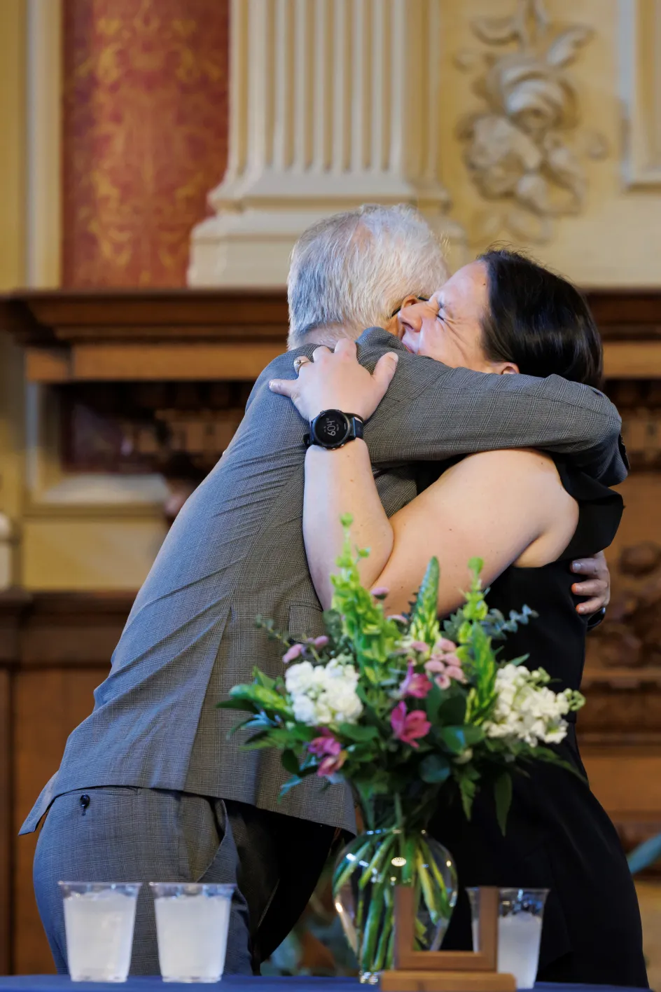Photo of Dean Hu and Betsy Sinclair hugging after Sinclair's installation