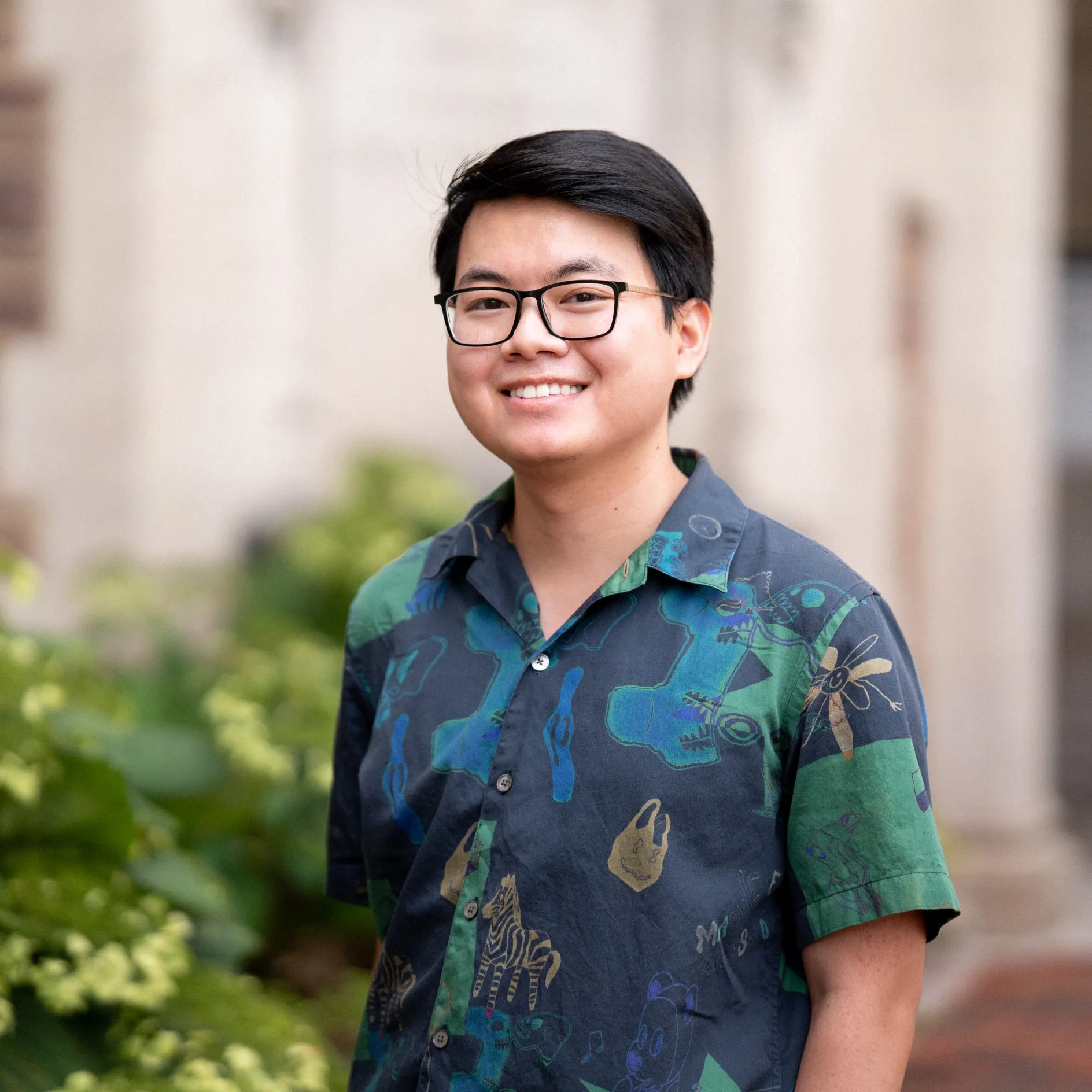 Photo of Thanh David Nguyen smiling in a multi-colored button up shirt