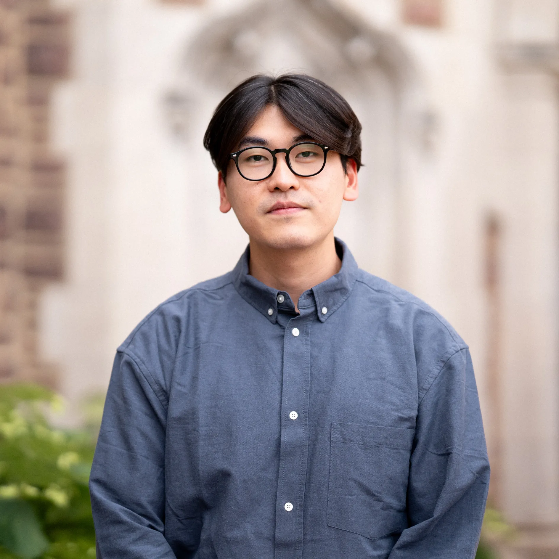 Photo of Tae Sung Oh wearing glasses in a blue button-up shirt